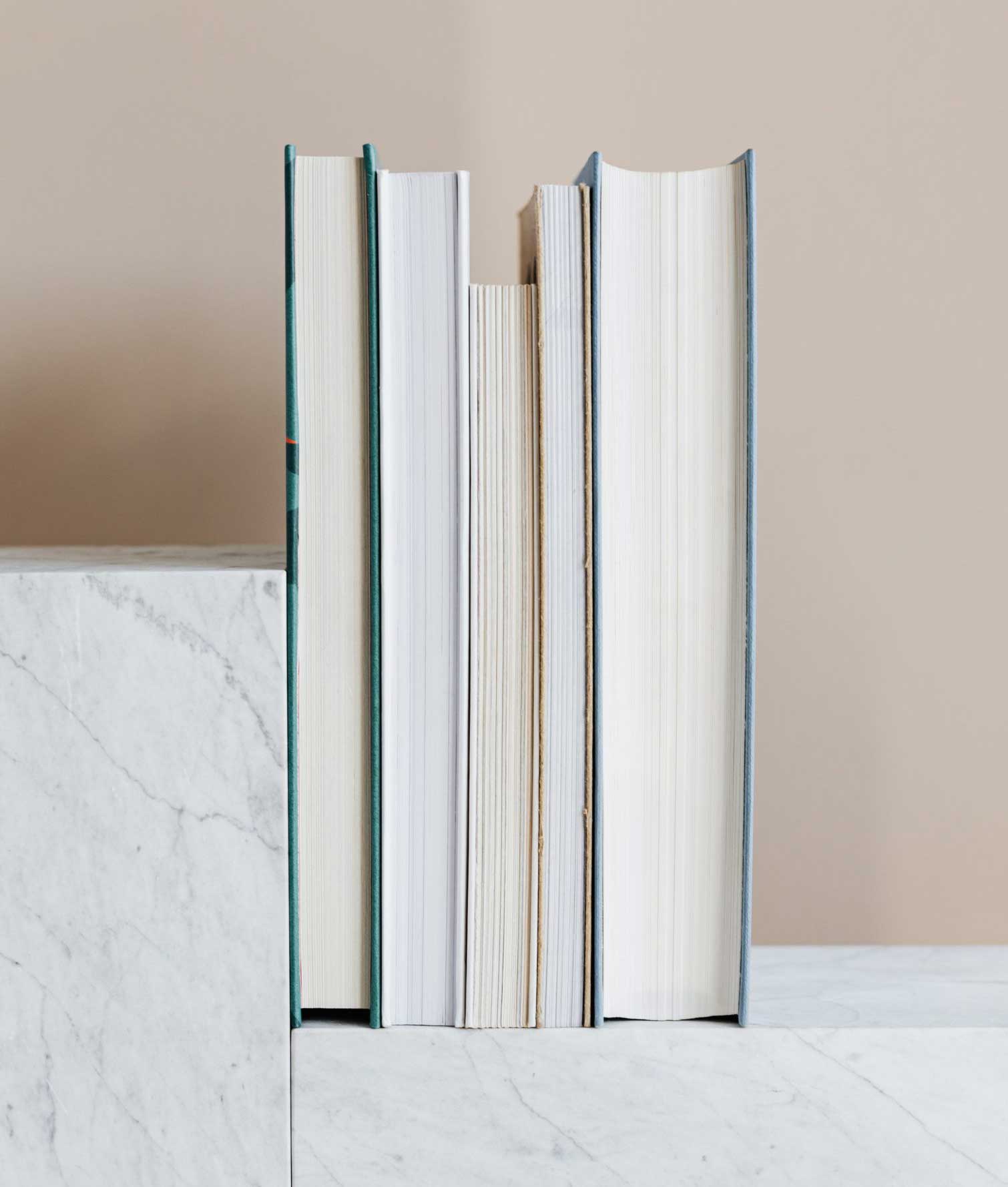 five books lined up on marble shelf